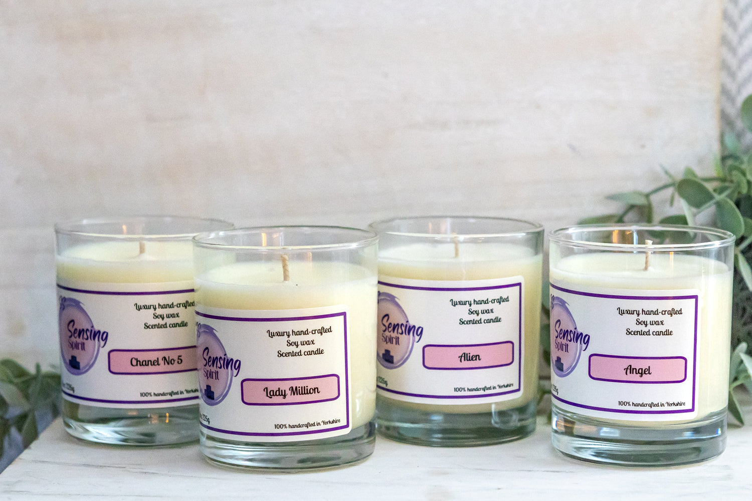 Luxury fragrance candle collection featuring Angel by Mugler, Alien by Mugler, Lady Million, and Chanel No5 soy wax candles