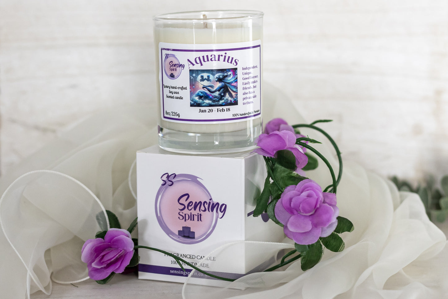 Candle with Aquarius label and Sensing Spirit packaging on a white background